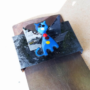 Création unique d'un chat bleu en émail d'un enfant pendant le stage de découverte.