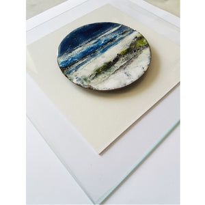 Création murale composée d'un disque de cuivre émaillé fixé sur une plaque de verre.
