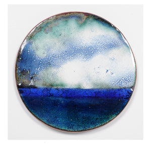 Objet d'art contemporain, en émaux joailliers sur cuivre de forme ronde, représentation de la mer et du ciel, dans un dégradé de bleus et de verts.