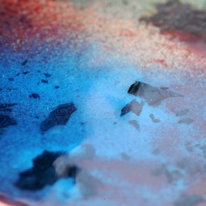 Gros plan sur les bleus de cette décoration murale, représentant une vue  à travers le hublot d'un bateau imaginaire. Disque de cuivre émaillé, fixé sur une plaque de verre.