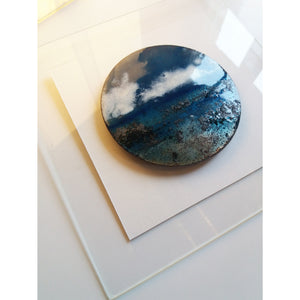 La pièce unique d'art es présenté avec son encadrement en verre. Ce disque bleu de cuivre en émaux, fabriqué a la main.